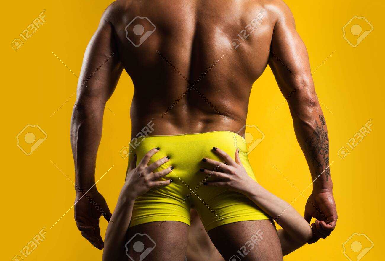 Ein Mann In Gelber Unterhose Auf Einem Orangefarbenen Hintergrund Isoliert.  Herren In Unterwäsche. Gesäß In Boxershorts. Nackter Oberkörper, Männlicher  Arsch. Oraler Sex. Frau Mit Der Zunge Des Männlichen Gesäßes. Lizenzfreie  Fotos, Bilder