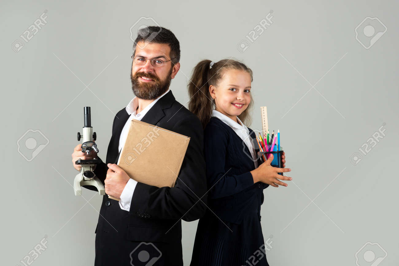 興奮した幸せな生徒の女子校生と笑顔の先生。学用品を持つ面白い女子高生と家庭教師の肖像画。灰色の幸せな先生と学生の女の子。学校に戻って、制服を着た学生の女の子。の写真素材・画像素材  Image 177830139