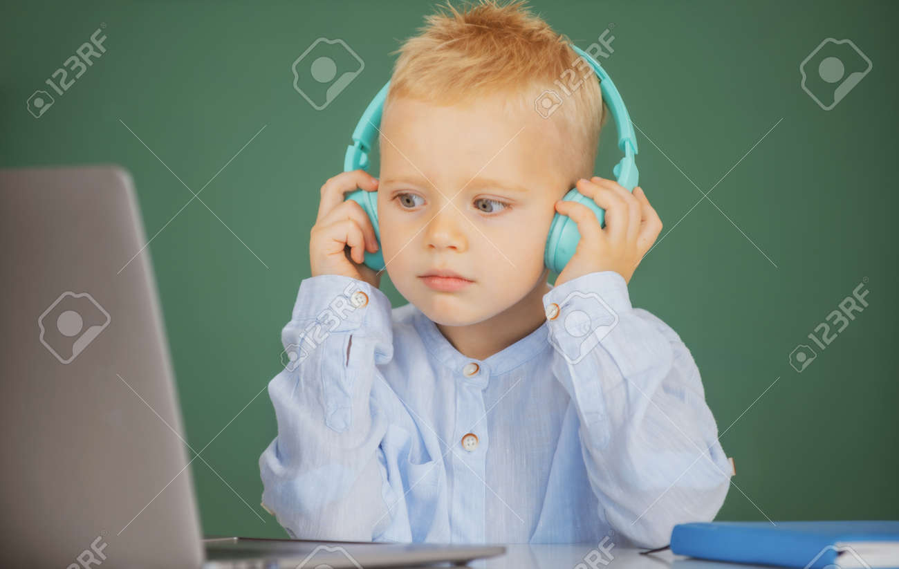Small Boy In Headphones Watch Video Lesson On Computer In School