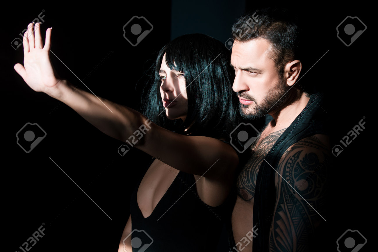 Passionate couple in shadows, intense embrace and desire