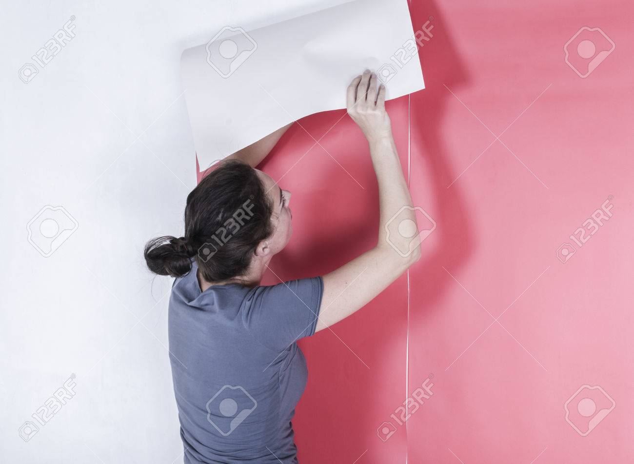 Woman hanging wallpaper Decorating the wall - 26249592 Woman hanging wallpaper Decorating the wall - 26249592