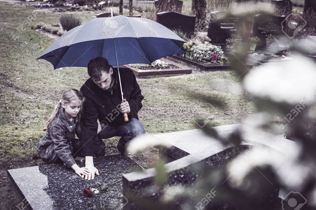widower and his doughtier at graveyard at mothers gravestone - 26559178 widower and his doughtier at graveyard at mothers gravestone - 26559178
