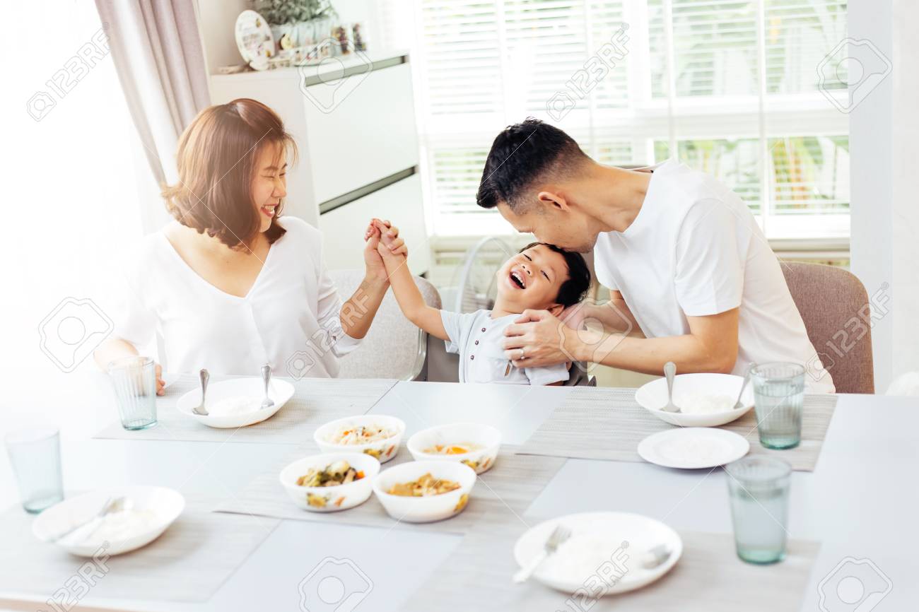 Happy Asian family of father, mother and son playing and laughing while having dinner - 100021275 Happy Asian family of father, mother and son playing and laughing while having dinner - 100021275