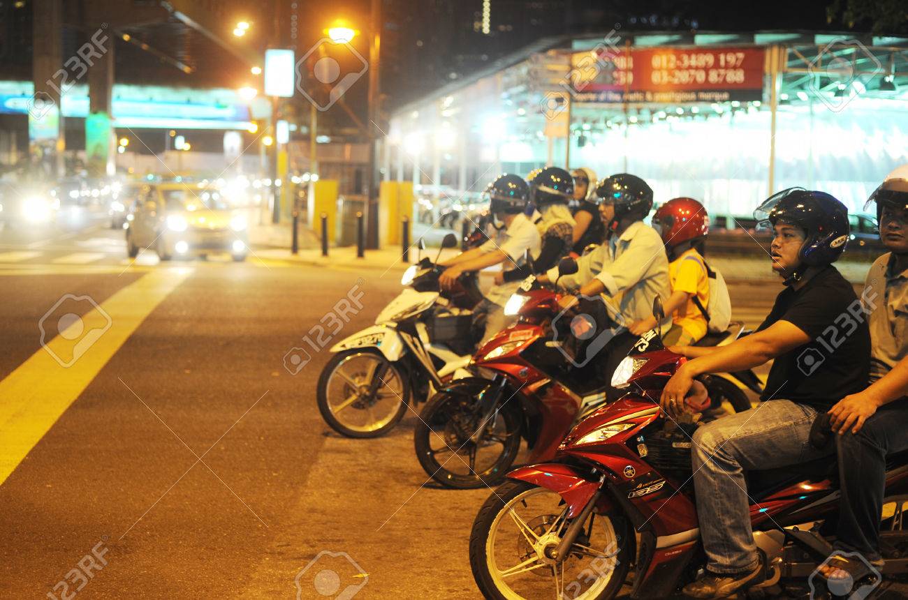 KUALA LUMPUR, MALAYSIA - MARCH 16, 2012: Motorcyclist on the road in Kuala Lumpur. The road network system in Kuala Lumpur is similar to the city road network system in major Chinese cites - 28661585 KUALA LUMPUR, MALAYSIA - MARCH 16, 2012: Motorcyclist on the road in Kuala Lumpur. The road network system in Kuala Lumpur is similar to the city road network system in major Chinese cites - 28661585