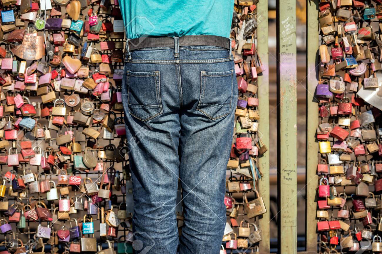 An abstract photograph of a torso of a person standing in front of the hundreds of love locks attached to the Hohenzollern Bridge in Cologne, Germany. - 142589313 An abstract photograph of a torso of a person standing in front of the hundreds of love locks attached to the Hohenzollern Bridge in Cologne, Germany. - 142589313
