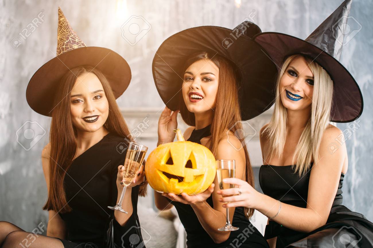 three friends sit on bed and drink champagne Halloween party - 88086340 three friends sit on bed and drink champagne Halloween party - 88086340