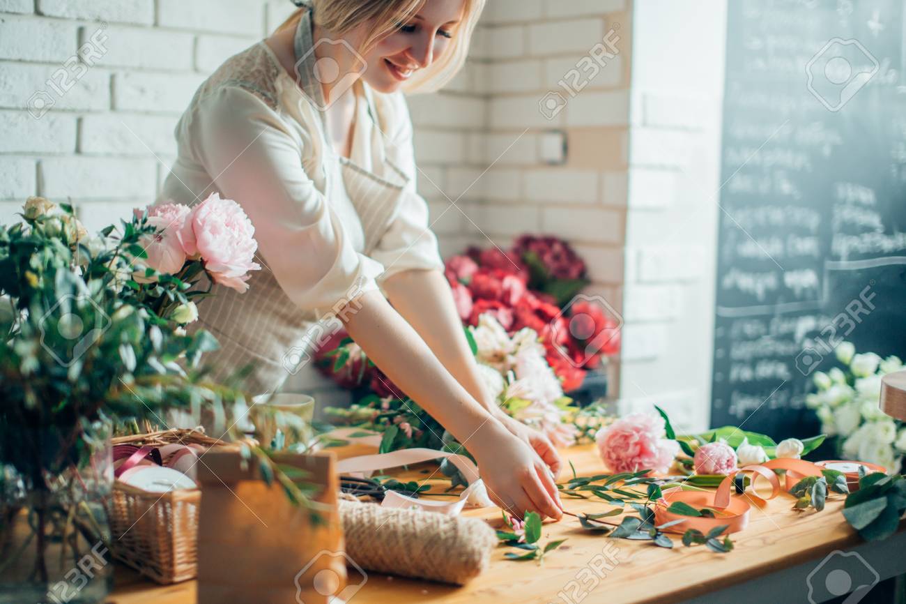 Florist workplace: woman arranging a bouquet with flowers - 91682177 Florist workplace: woman arranging a bouquet with flowers - 91682177