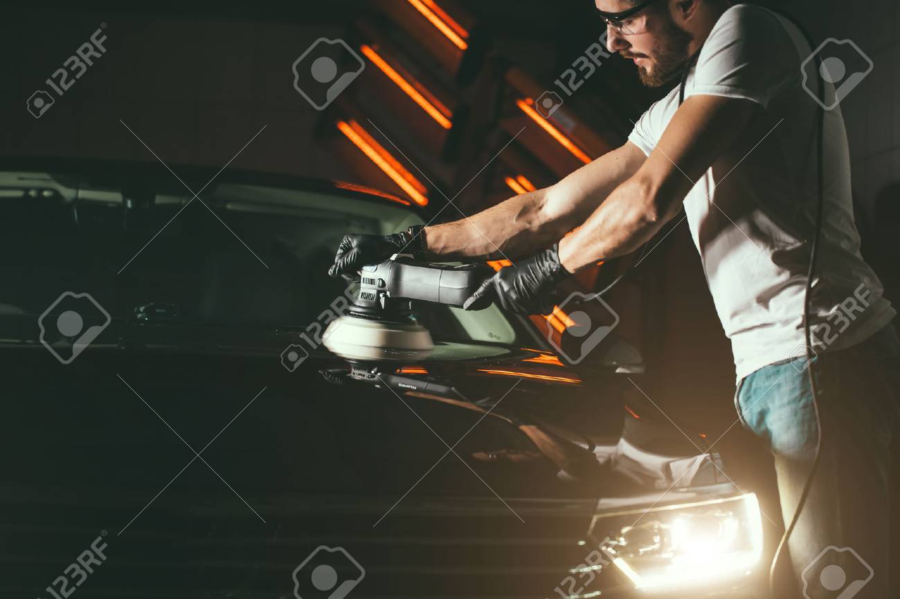 Car detailing - man with orbital polisher in auto repair shop. Selective focus. - 93797387 Car detailing - man with orbital polisher in auto repair shop. Selective focus. - 93797387