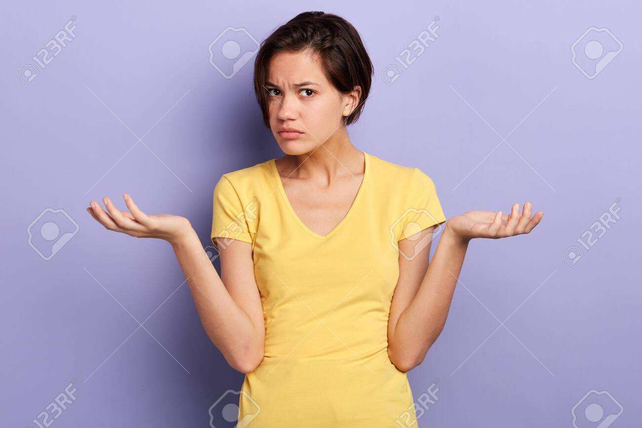 serious girl cannot understand her friend, woman being puzzled with suggestion, offer, close up portrait, isolated violet background, studio shot - 129720439 serious girl cannot understand her friend, woman being puzzled with suggestion, offer, close up portrait, isolated violet background, studio shot - 129720439