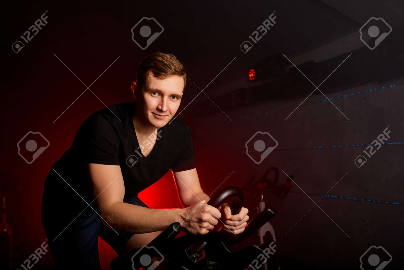 male sitting on bike in gym posing at camera, workout ride a bike in gym, with the intention of healthcare - 169212517 male sitting on bike in gym posing at camera, workout ride a bike in gym, with the intention of healthcare - 169212517