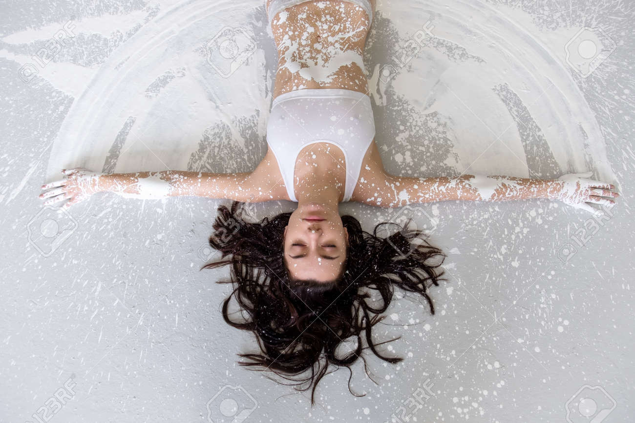 Artísticamente Abstracto Pintado En Blanco Mujer En Ropa Interior, Deportiva, Yace En El Suelo En El Estudio De Artistas, Copia Espacio. Fotos, Retratos, Imágenes Y De Archivo Libres