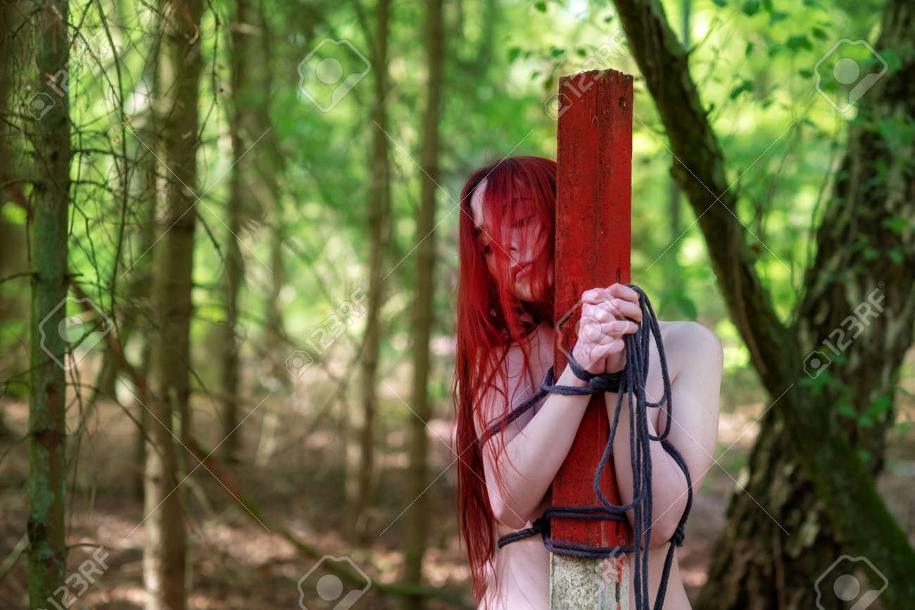 Young Sexy Naked Woman With Red Hair Is Tied To A Post With A Rope In The  Woods. Stock Photo, Picture and Royalty Free Image. Image 182127525.