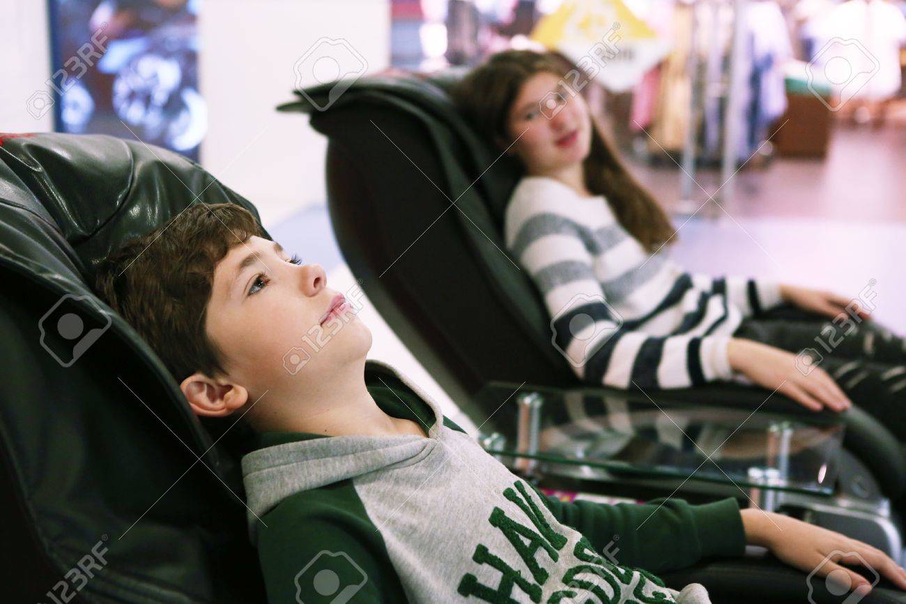 Stock Photo Teen Siblings Brother And Sister In Massage Chair In Shopping Mall Stock Photo Teen Siblings Brother And Sister In Massage Chair In Shopping Mall