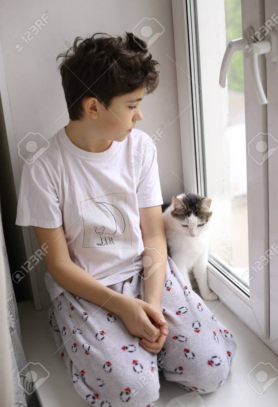 Garcon Adolescent En Pyjama Avec Chat Sur Le Rebord De La Fenetre Regarder La Fenetre Fermer Photo Banque D Images Et Photos Libres De Droits Image