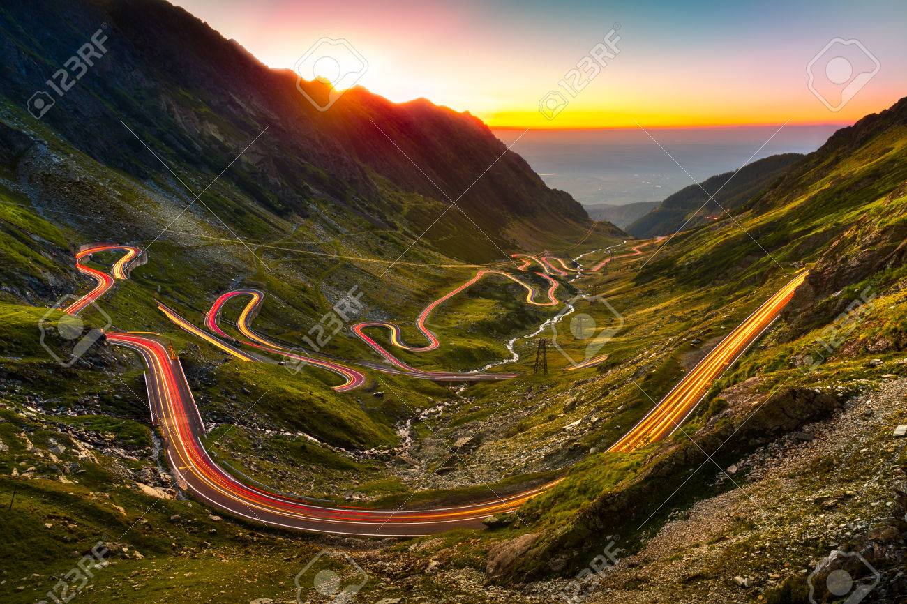 Traffic trails on Transfagarasan pass at sunset. Crossing Carpathian mountains in Romania, Transfagarasan is one of the most spectacular mountain roads in the world. - 64612907 Traffic trails on Transfagarasan pass at sunset. Crossing Carpathian mountains in Romania, Transfagarasan is one of the most spectacular mountain roads in the world. - 64612907