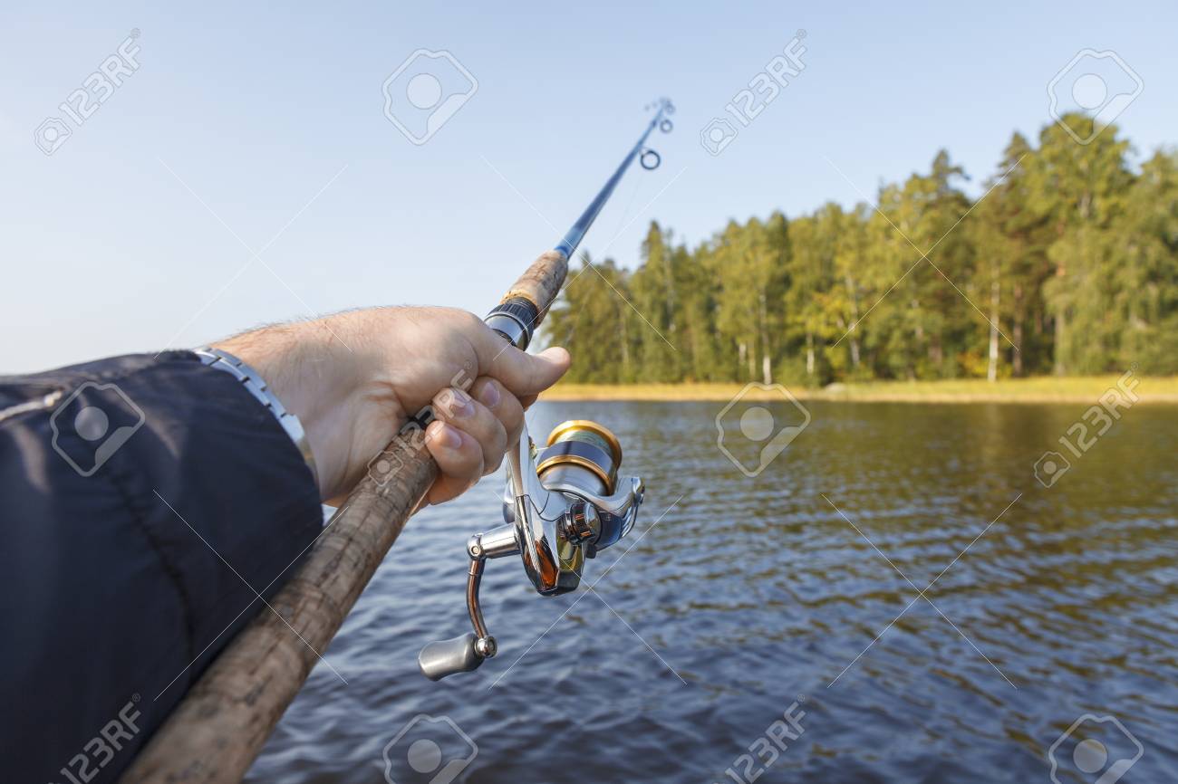 湖で釣り リールとロッドを手に釣り 海岸の Vew の写真素材 画像素材 Image