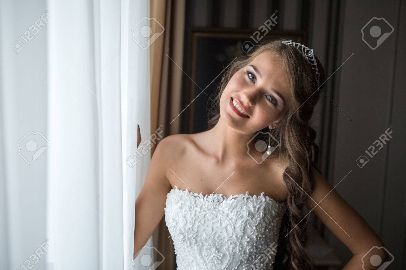 幸せな花嫁の結婚式の前に窓が寝室で写真のポーズします 花嫁は 1 つの側面と笑みを浮かべて首をかしげていた の写真素材 画像素材 Image 幸せな花嫁の結婚式の前に窓が寝室で写真のポーズします 花嫁は 1 つの側面と笑みを浮かべて首をかしげていた の写真素材 画像素材 Image