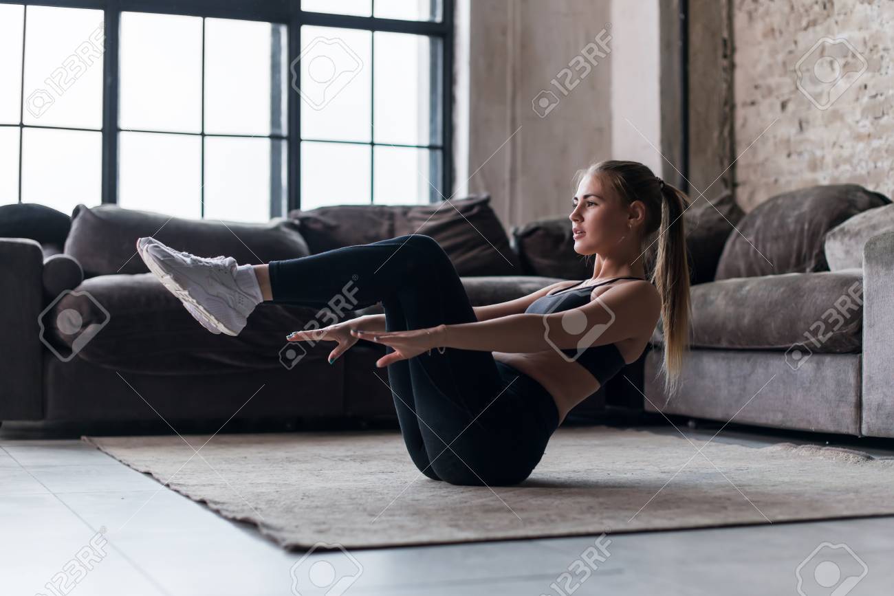 Slim sporty girl doing v-ups abs workout at home - 79540033 Slim sporty girl doing v-ups abs workout at home - 79540033