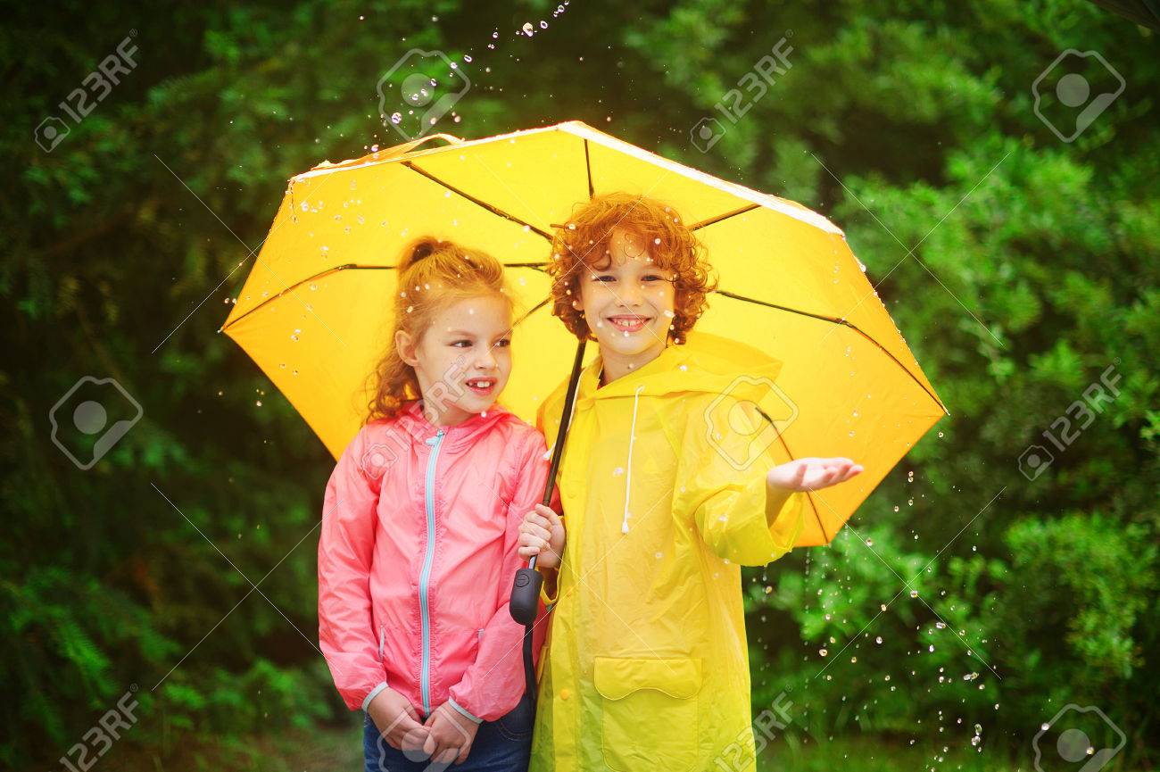 Brother And Sister Stand Together Under A Big Yellow Umbrella The Little Girl Is Dressed Brother And Sister Stand Together Under A Big Yellow Umbrella The Little Girl Is Dressed