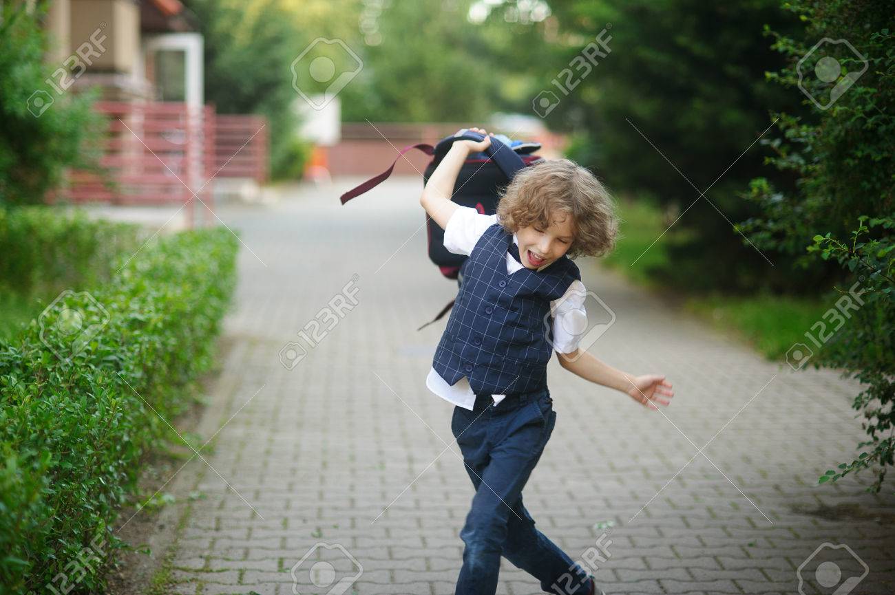 学校の校庭で小瞳孔 怒って彼のバックパックを振っている少年 の写真素材 画像素材 Image