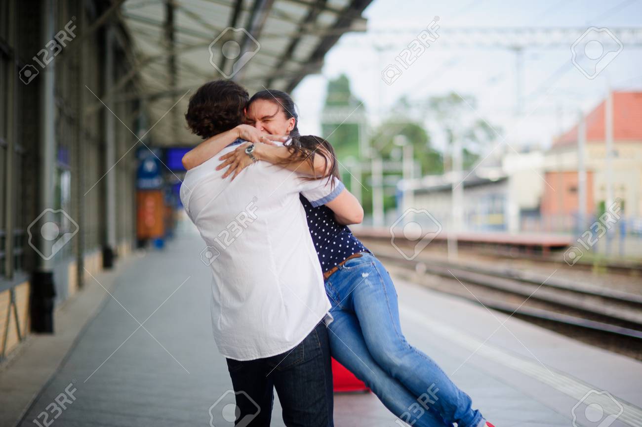 うれしそうな駅で会議します 若い男は 少女を持ち上げた ハグのカップル 少女は幸福に目を閉じました の写真素材 画像素材 Image