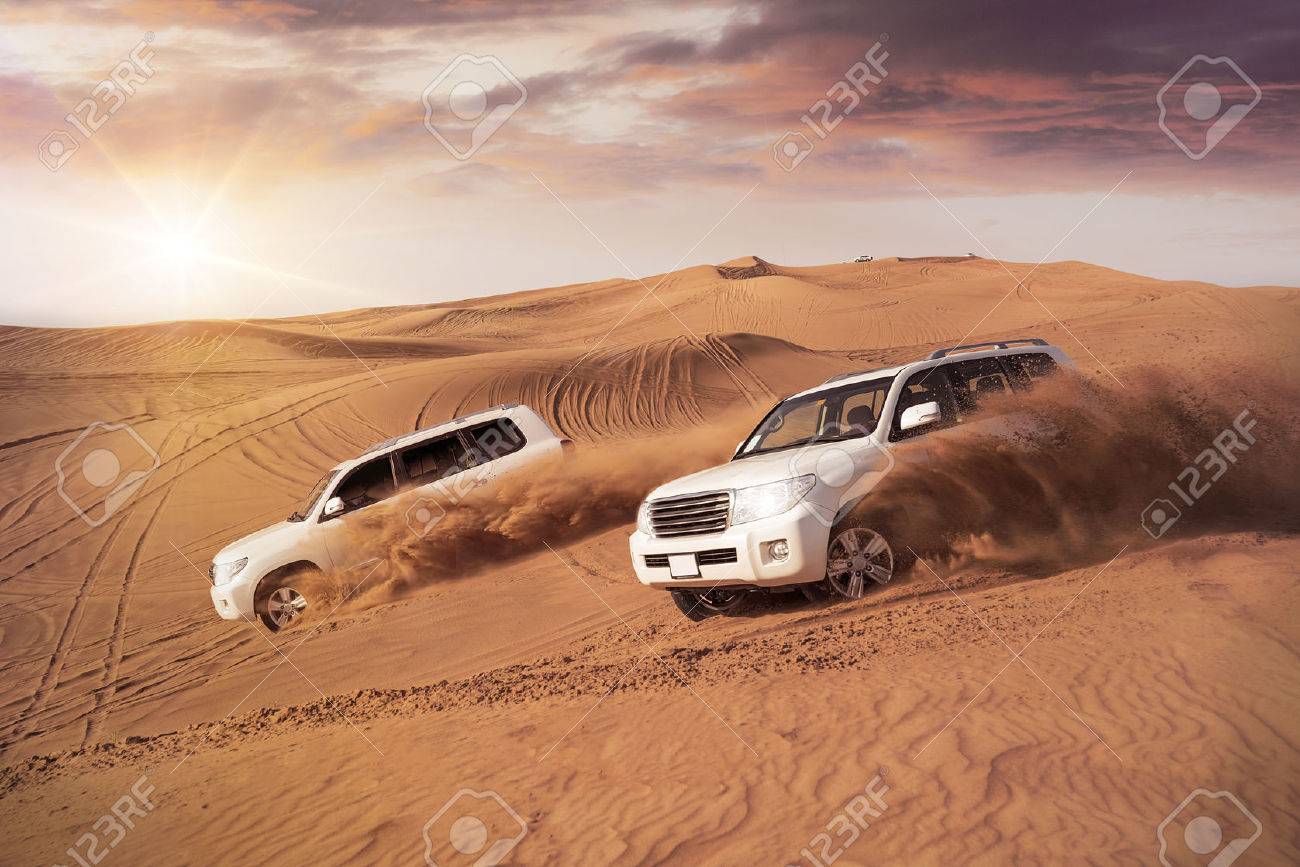 two 4x4 vehicles bashing side to side through the desert dunes in the evening sun - 54905518 two 4x4 vehicles bashing side to side through the desert dunes in the evening sun - 54905518