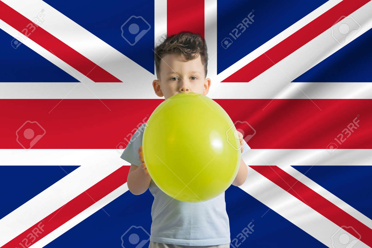 Children's day in United Kingdom. White boy with a balloon on the background of the flag of United Kingdom. Childrens day celebration concept. - 170833865 Children's day in United Kingdom. White boy with a balloon on the background of the flag of United Kingdom. Childrens day celebration concept. - 170833865