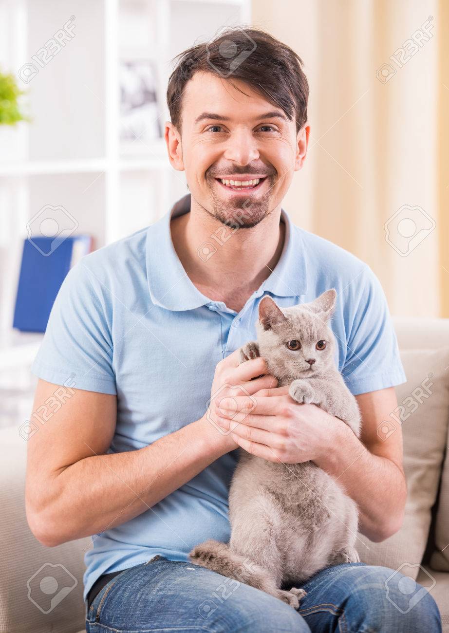 Sourire Jeune Homme Avec Son Chat Mignon Sur Le Canape A La Maison Banque D Images Et Photos Libres De Droits Image