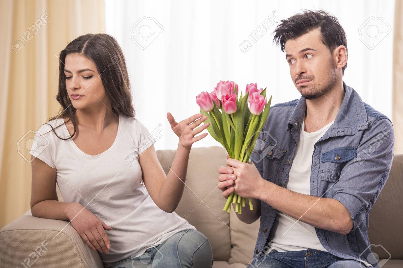 Young Man Is Offering A Bunch Of Flowers To His Angry Girlfriend.. Stock  Photo, Picture And Royalty Free Image. Image 37594310.