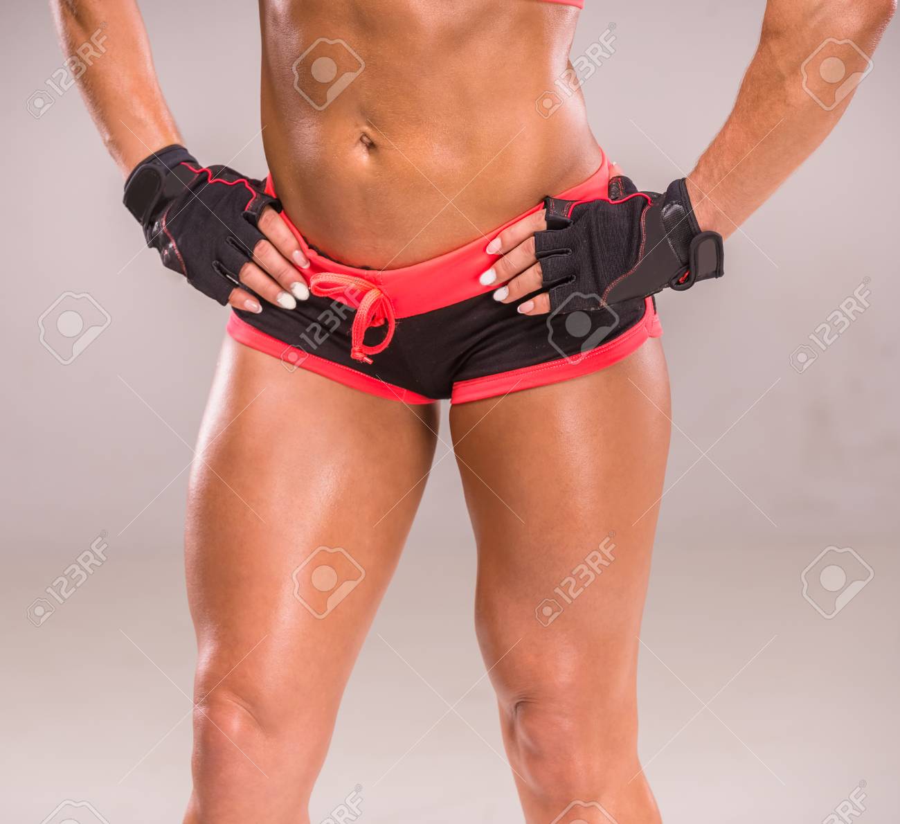 美しい筋肉ボディービルダー女のクローズ アップは灰色の背景にポーズをとってください の写真素材 画像素材 Image