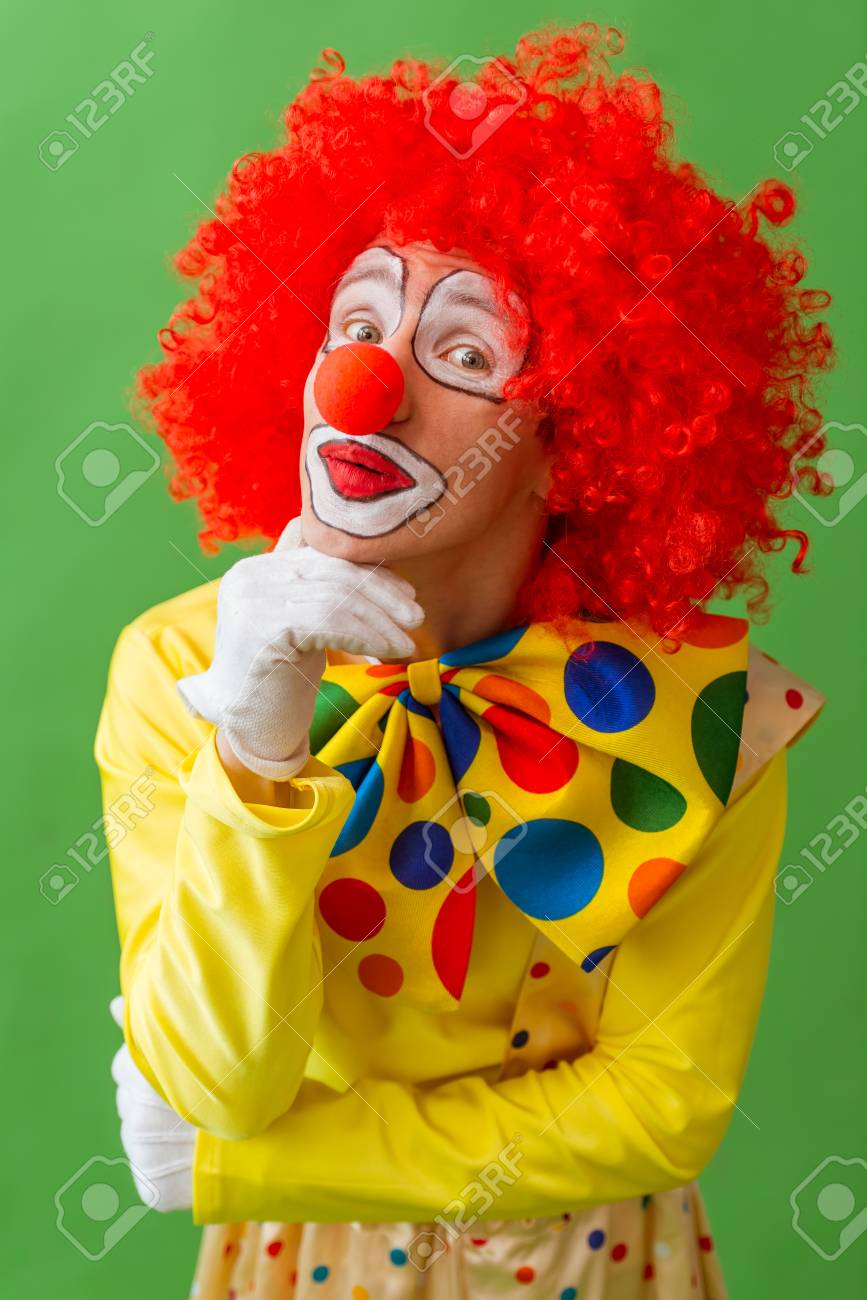 Portrait Of A Funny Playful Clown In Red Wig Making Thoughtful ...