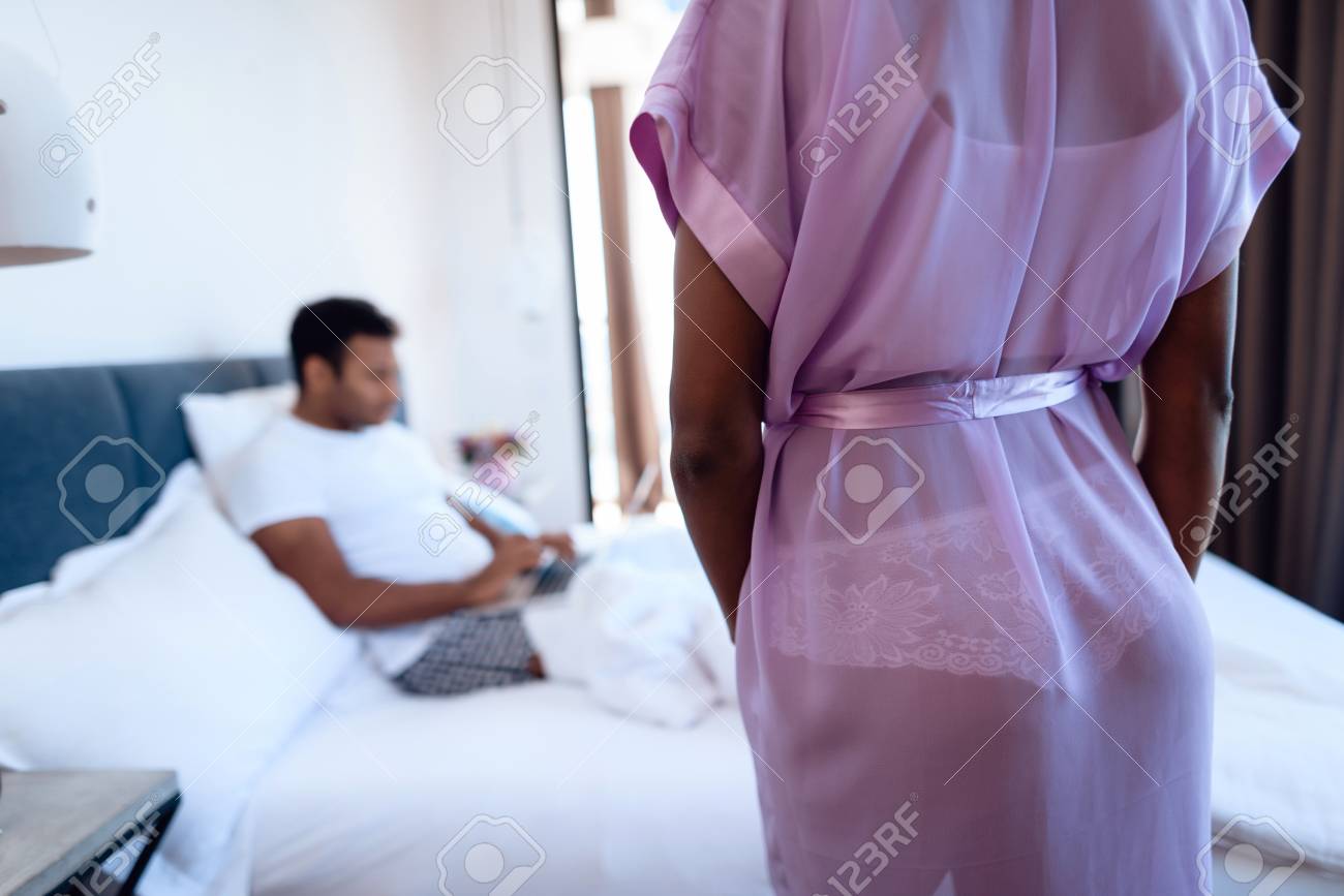 Homem Negro E Mulher No Quarto Um Homem Esta Deitado Na Cama Com O Laptop Antes Dele E Sua Garota Em Lingerie Sexy Fotos Retratos Imagenes Y Fotografia De Archivo Libres De
