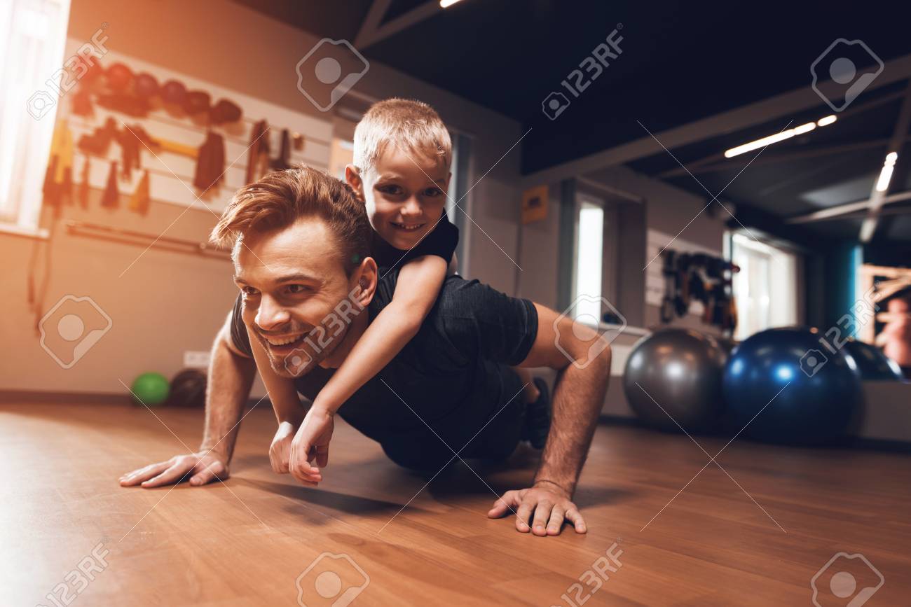Father and son in the gym. Father and son spend time together and lead a healthy lifestyle. Man and boy are working out. Father and son are doing exercise. - 96221516 Father and son in the gym. Father and son spend time together and lead a healthy lifestyle. Man and boy are working out. Father and son are doing exercise. - 96221516