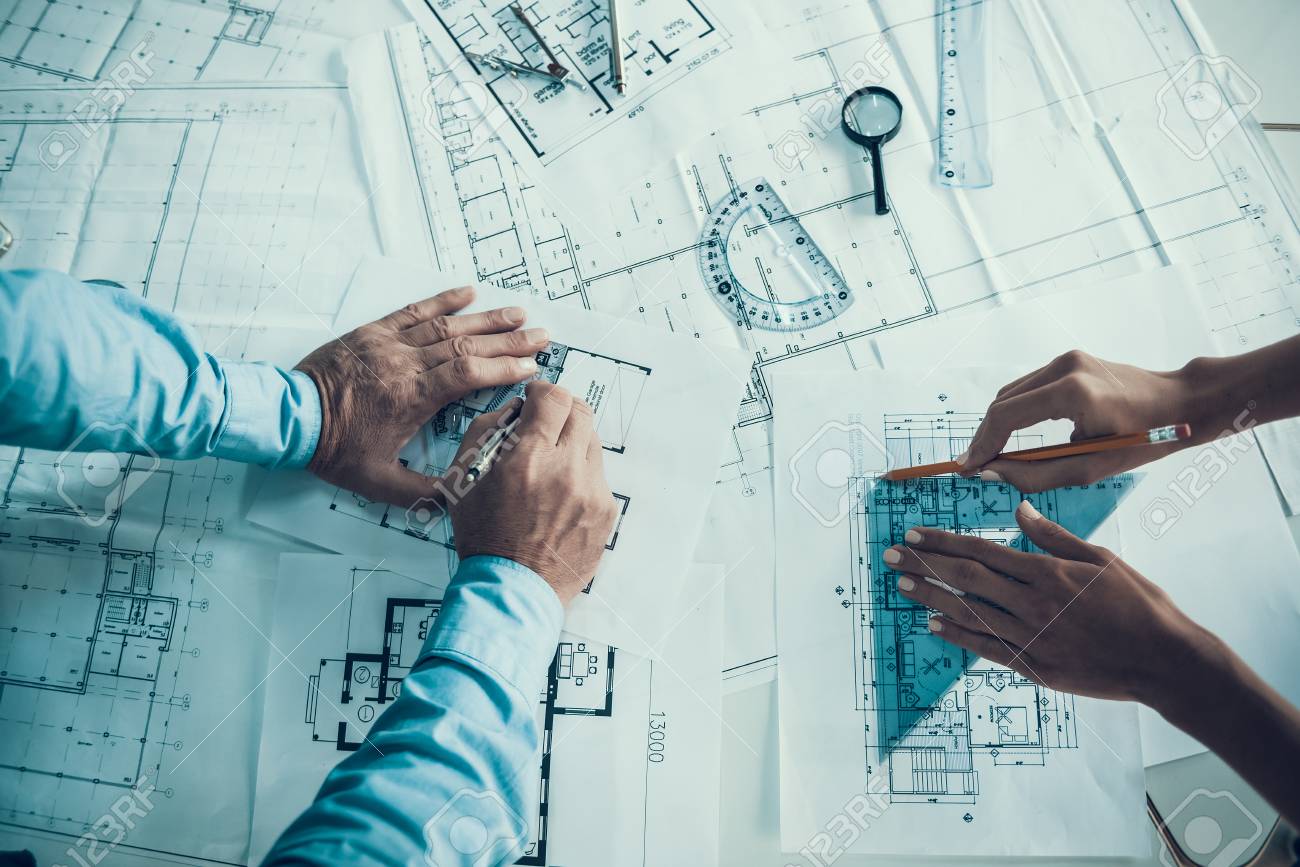 Closeup of hands of architects Drawing Blueprint. Two Creative Colleagues Designing Plan of new Building Together in Office. Business Corporate People Working Together. Team work Concept - 107272200 Closeup of hands of architects Drawing Blueprint. Two Creative Colleagues Designing Plan of new Building Together in Office. Business Corporate People Working Together. Team work Concept - 107272200