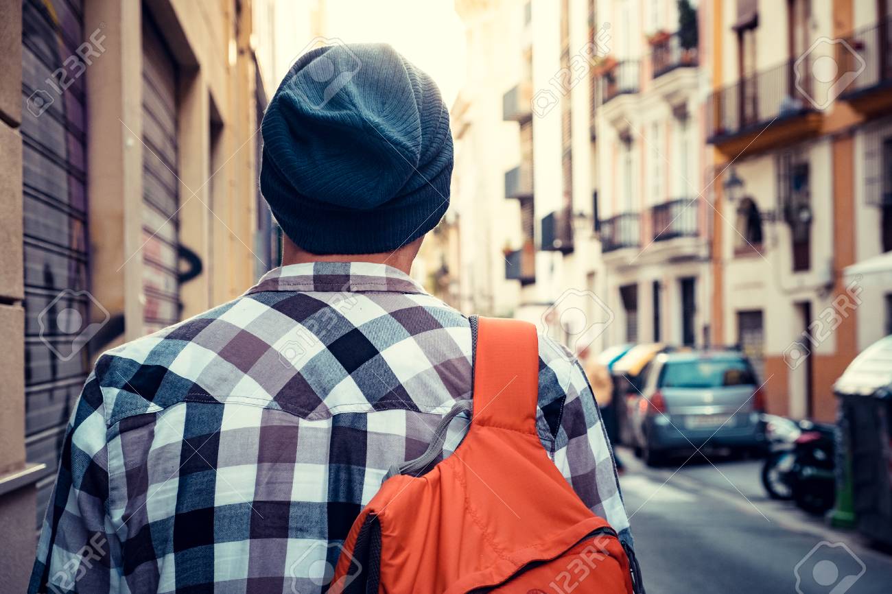 Turista Joven Con Mochila Está Caminando Por La Calle En Una Ciudad Europea. Fotos, Retratos, Imágenes Y Fotografía De Archivo Libres De Derecho. Image 52650468.