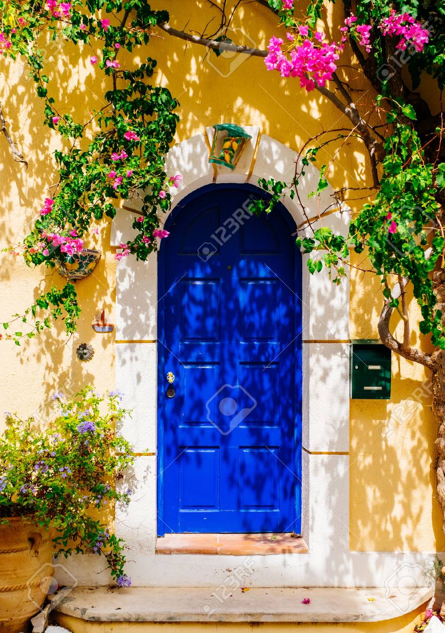 Facade of traditional Greek building with beautiful pink flowers. Greece. Kefalonia - 77821999 Facade of traditional Greek building with beautiful pink flowers. Greece. Kefalonia - 77821999