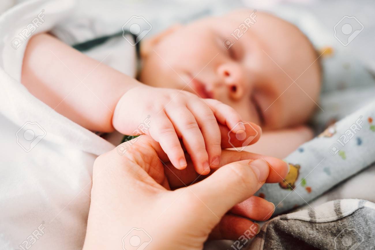 Cute Little Baby Holding Mother's Hand While Sleeping. Happy Family Concept. Stock Photo, Picture and Royalty Free Image. Image 96080722.