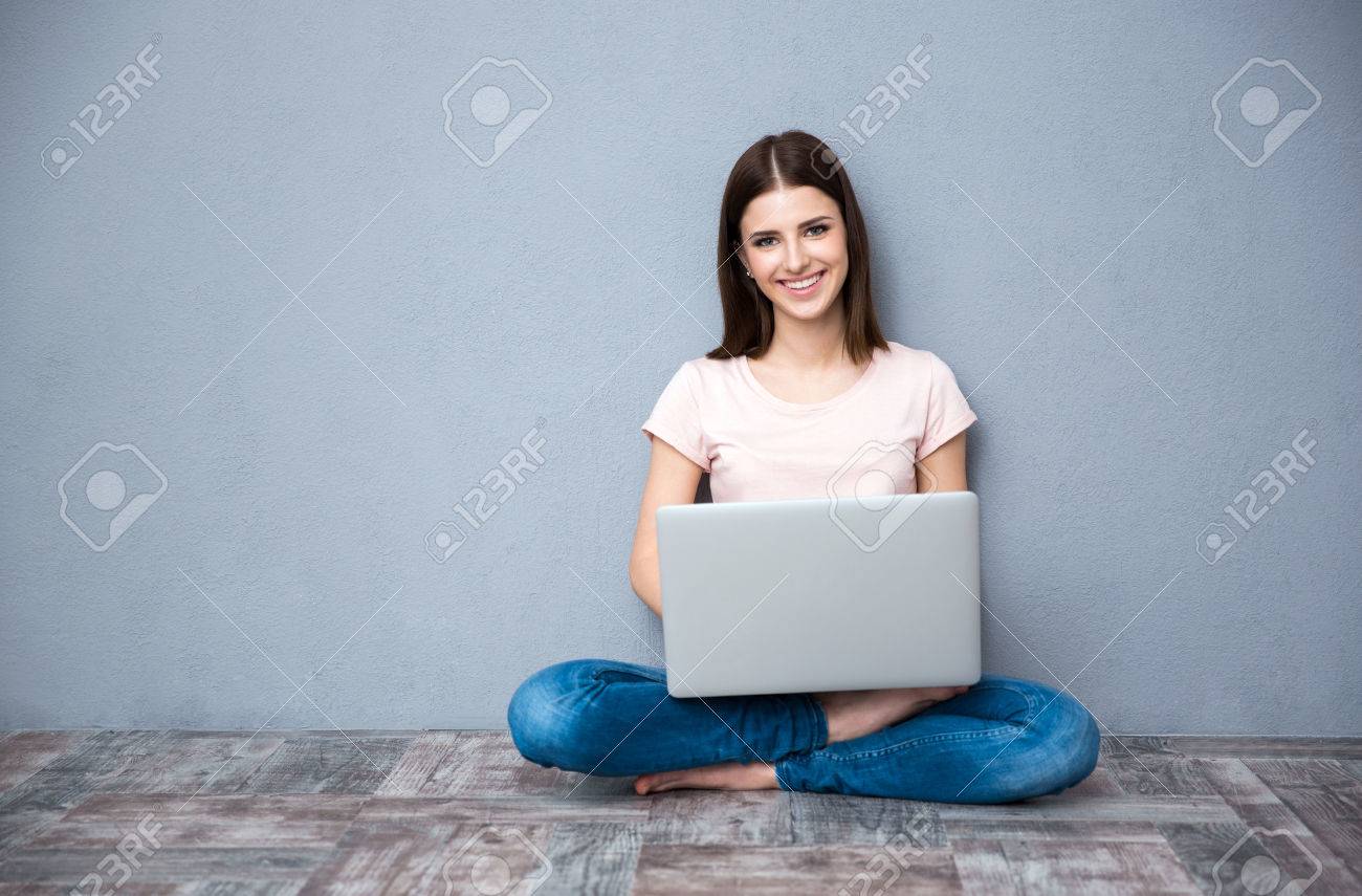 Young smiling woman sitting on the floor and using laptop - 38057719 Young smiling woman sitting on the floor and using laptop - 38057719
