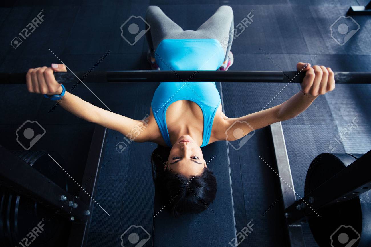 若い女性ジムでベンチでバーベルでワークアウトに合います バーのベンチ プレ の写真素材 画像素材 Image