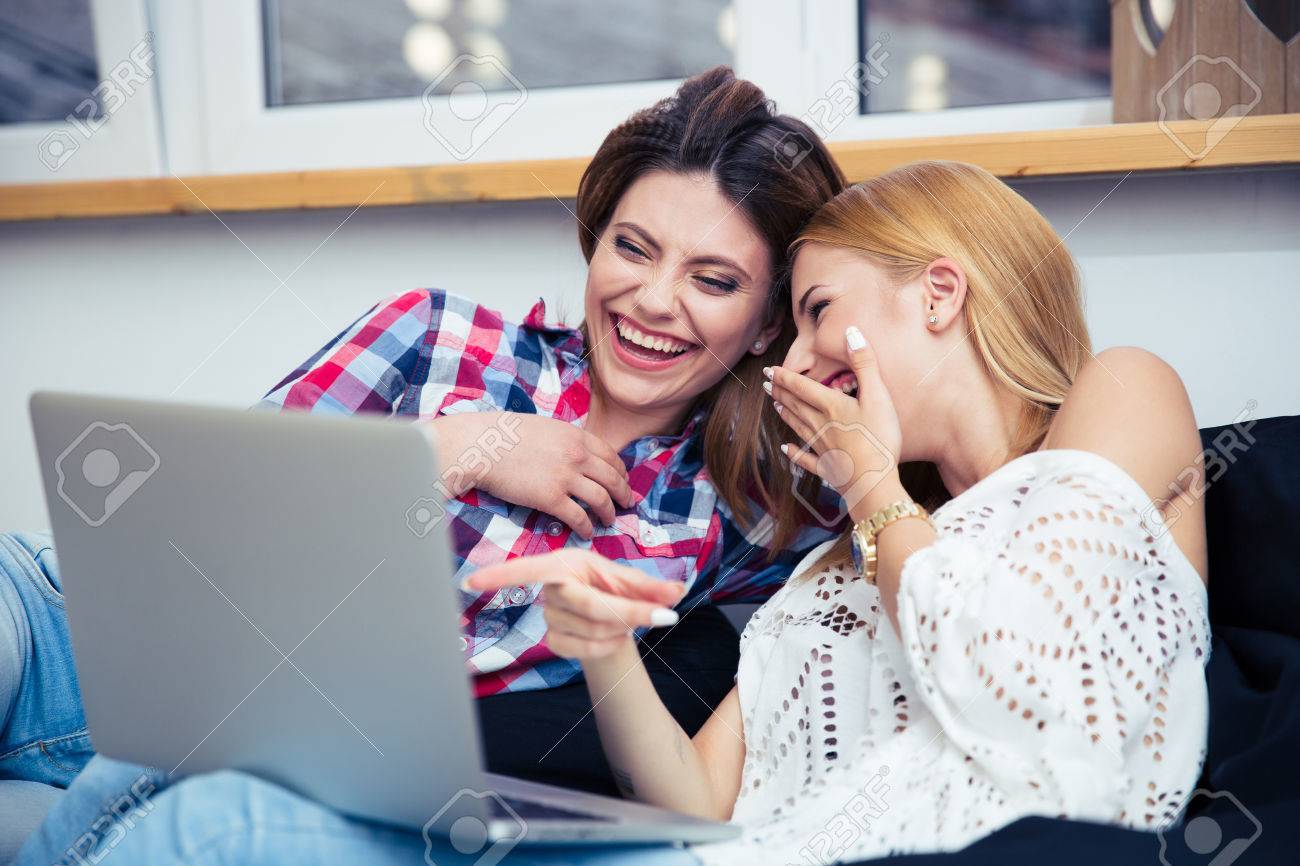 ソファの上に座って ノート パソコンに映画を見て二人の笑う女の子 の写真素材 画像素材 Image