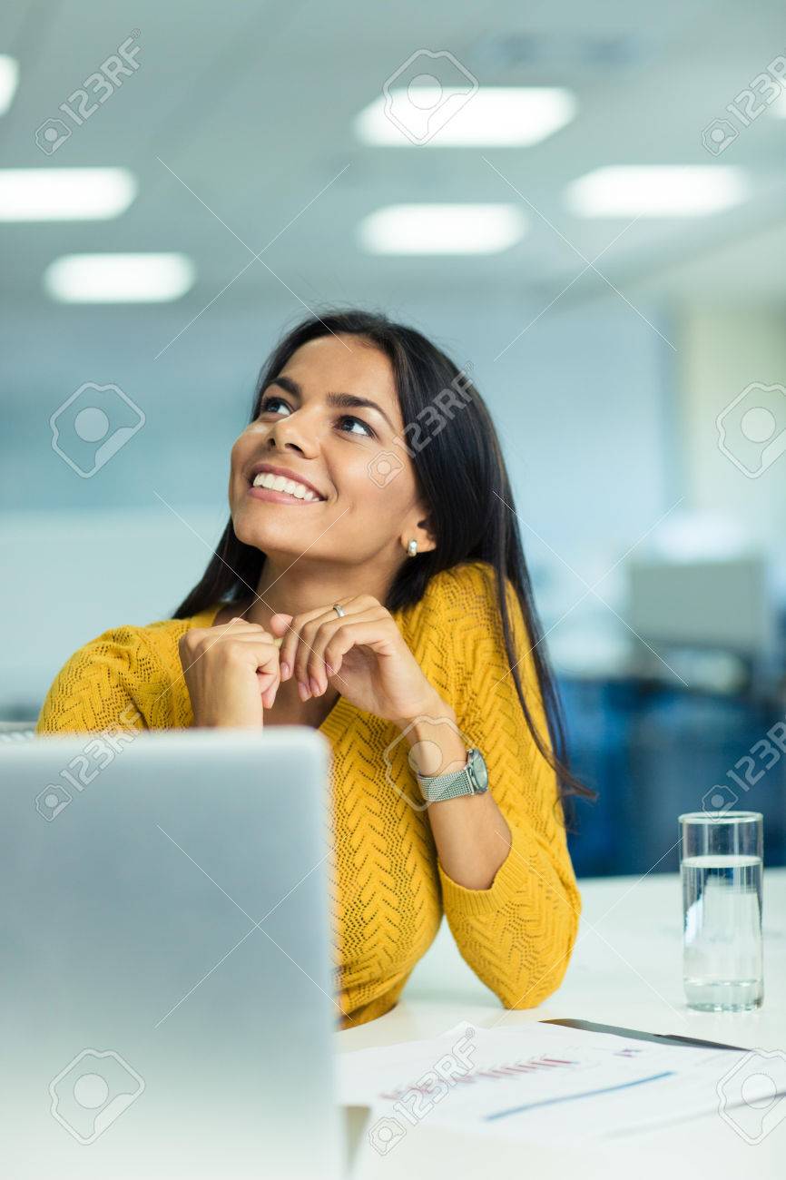 見上げると彼女の職場のオフィスで座っている笑顔かわいい実業家の肖像画 の写真素材 画像素材 Image
