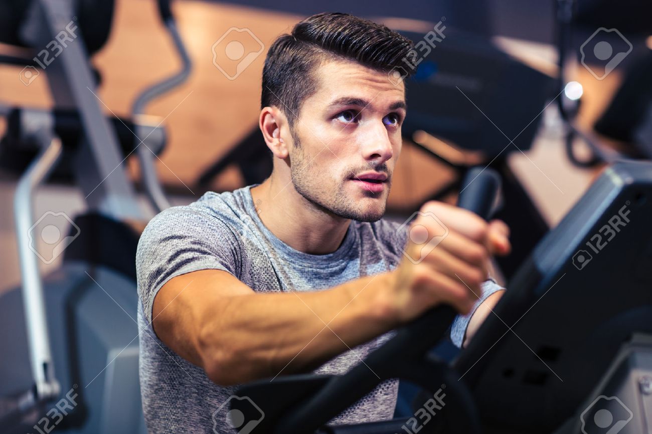 Portrait Of A Handsome Man Workout On A Fitness Machine At Gym Portrait Of A Handsome Man Workout On A Fitness Machine At Gym
