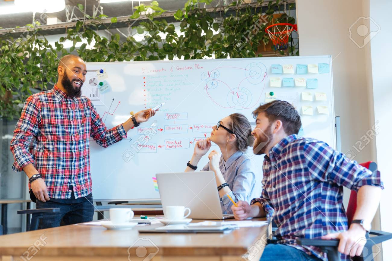 afro american man presenting business plan to his colleagues on meeting in office stock photo