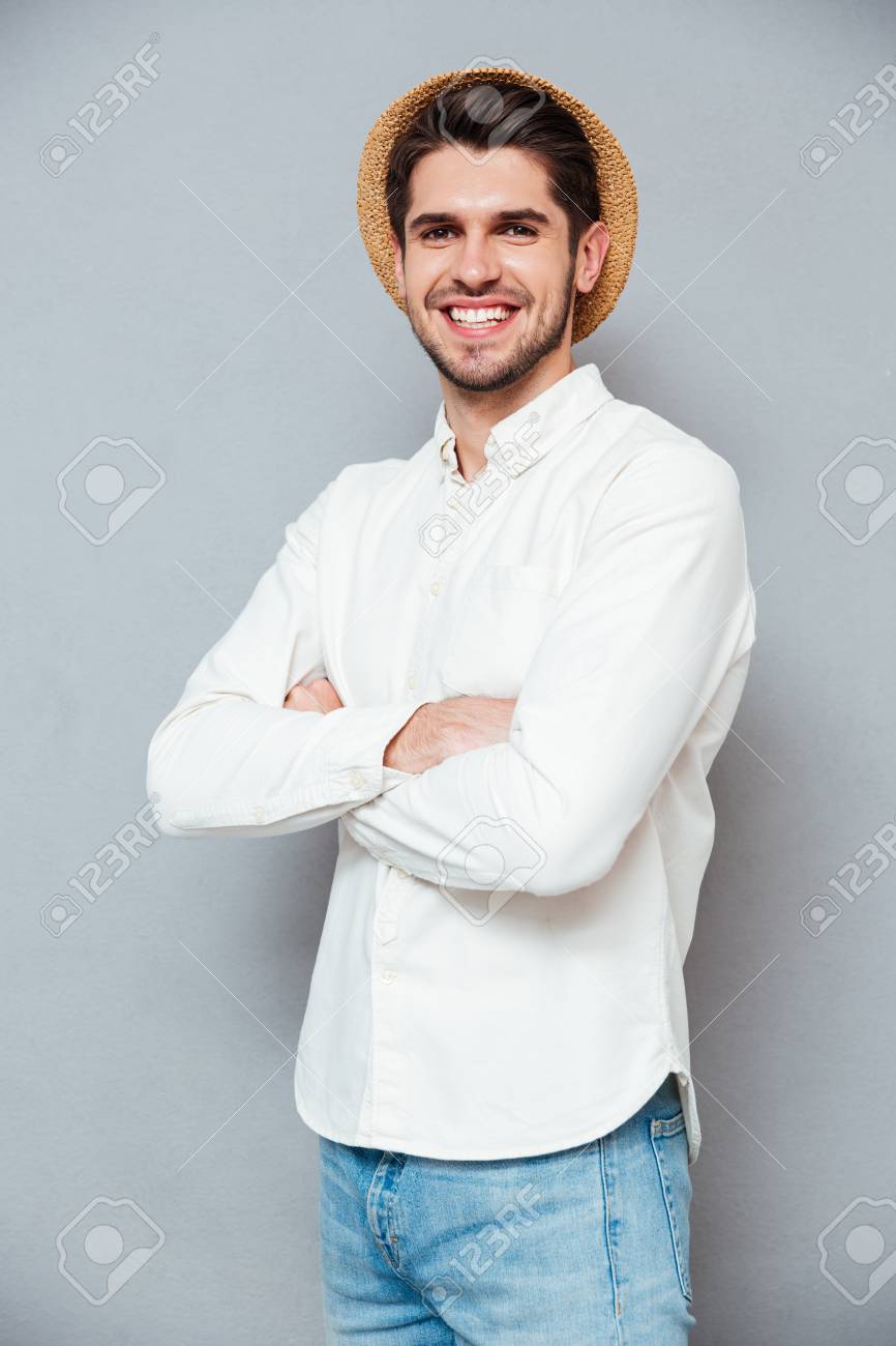 Alegre Joven Confía En Camisa Blanca Y Sombrero De Pie Con Encanto Atractivo. Retrato De Hombre Joven Confía En Camisa