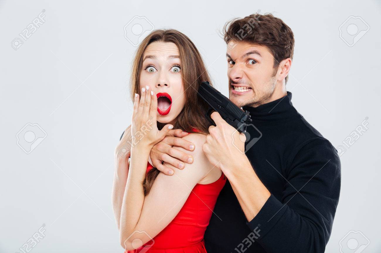 銃を持つ若い女性を怖がって脅迫狂った犯罪若い男 の写真素材 画像素材 Image 62643596