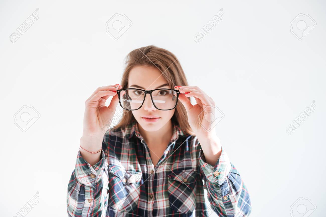 眼鏡をかけてカメラを見て 白い背景の上に立って ポーズの魅力的な女性のイメージ の写真素材 画像素材 Image