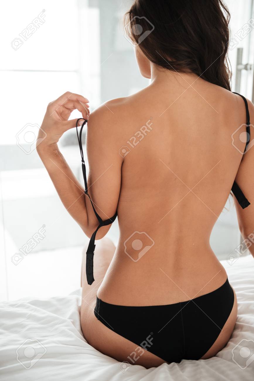 Photo Group of Back View a Young Woman Taking Off Her Bra Stock