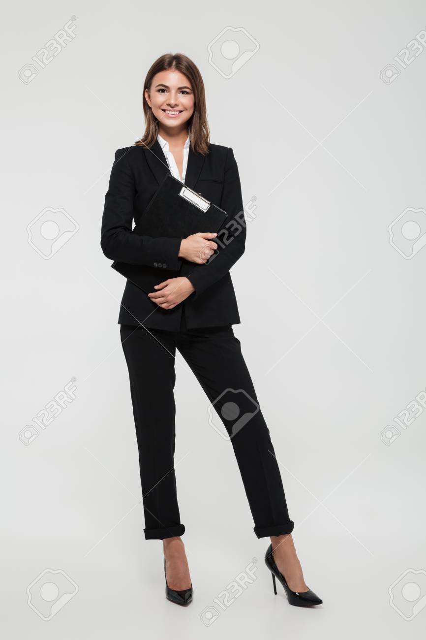 Full length portrait of a happy smiling businesswoman in suit holding clipboard and looking at camera isolated over white background - 89362206 Full length portrait of a happy smiling businesswoman in suit holding clipboard and looking at camera isolated over white background - 89362206