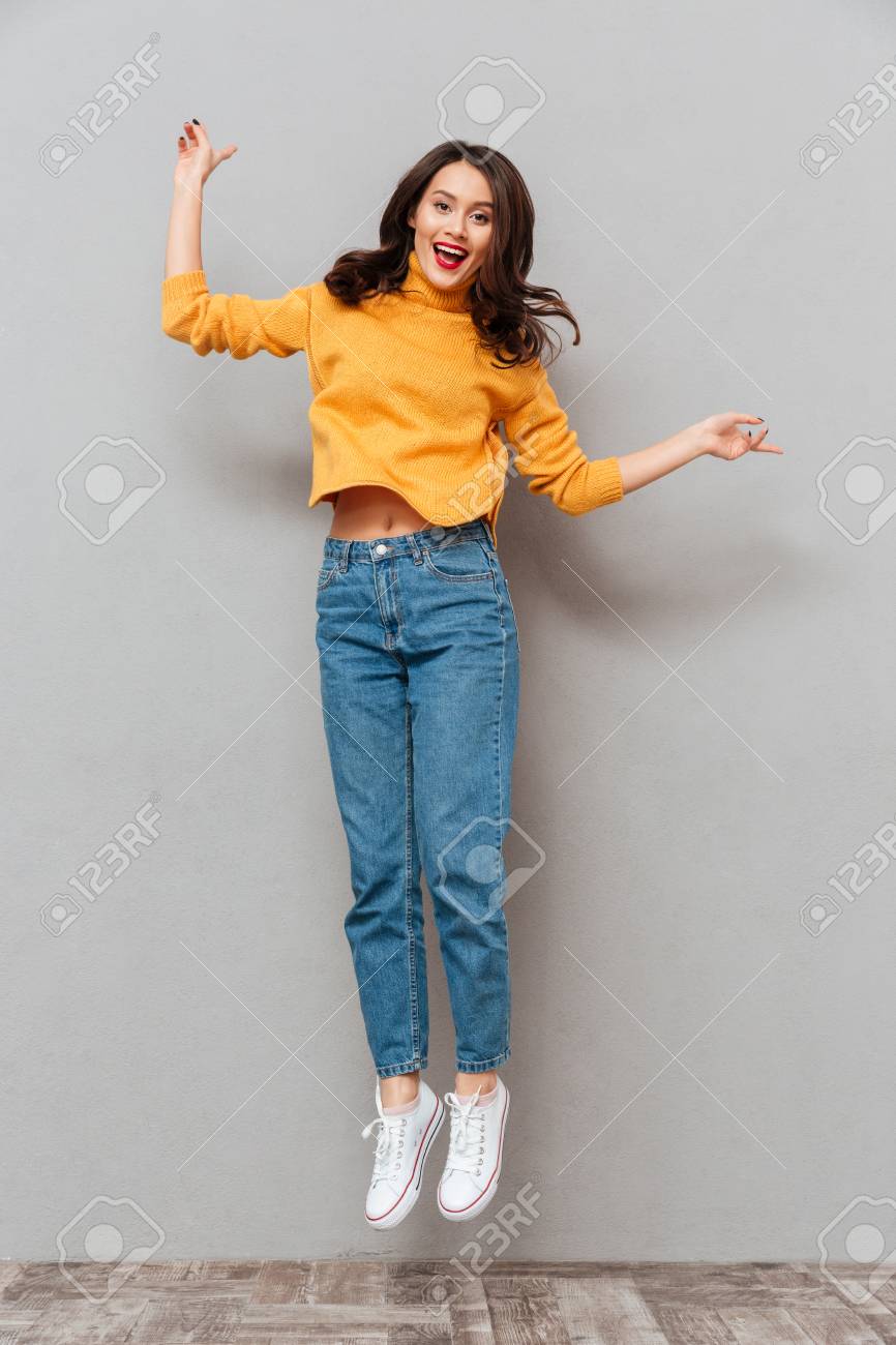 Full Length Image Of Cheerful Brunette Woman In Sweater Jumping