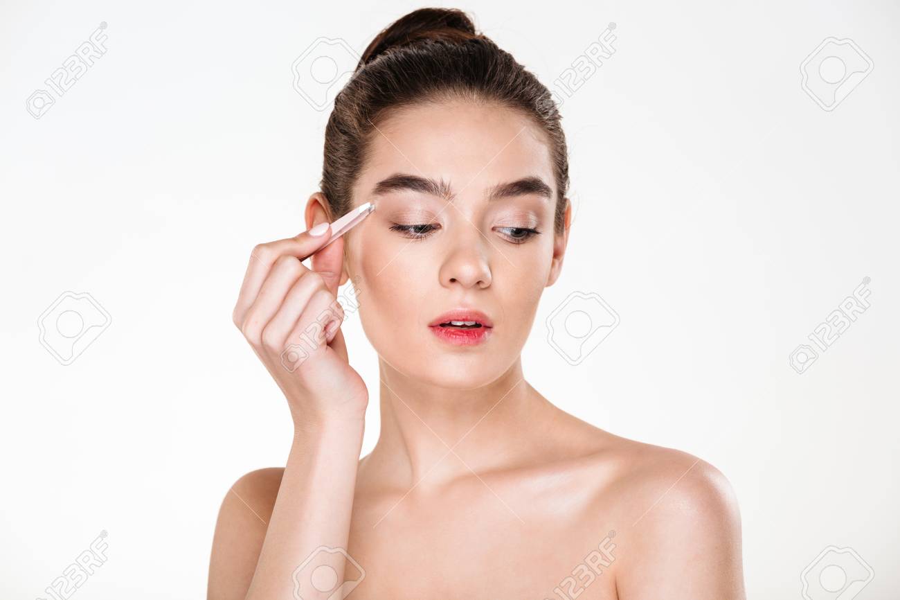 柔らかい肌を持つ若いかわいい女性の写真を閉じ 白い背景の上に隔離されたピンセットで眉毛を摘む の写真素材 画像素材 Image